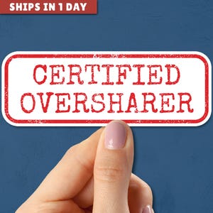 May include: A white sticker with a red border and the text "CERTIFIED OVERSHARER" in red.