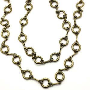 May include: Two antique gold-colored necklaces with a repeating circular link design. The links are connected by smaller, decorative bars. The necklaces are displayed on a white background, highlighting the intricate details of the jewelry.