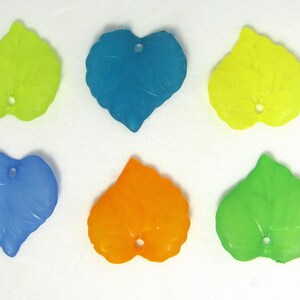 May include: Six plastic leaf-shaped charms in various colors: yellow, blue, light blue, orange, green, and lime green. Each charm has a hole in the center for stringing.