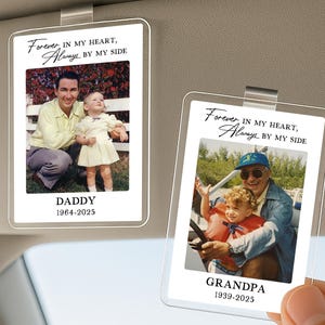 May include: Two clear car visor photo holders with family photos. One says "DADDY 1964-2025" and the other says "GRANDPA 1939-2025". Both have the text "Forever, IN MY HEART, Always BY MY SIDE" at the top.