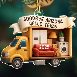 May include: A yellow moving truck ornament with the text "Goodbye Arizona Hello Texas" on a banner. The truck bed is filled with furniture, including a red sofa with "2025" on it, a refrigerator, and a washing machine.