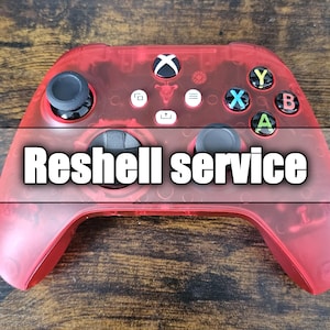 Puede incluir: Un mando de Xbox rojo transparente con joysticks negros y botones de colores. El texto "Reshell service" está superpuesto en el mando. El mando está sobre una superficie de madera.