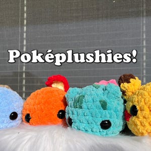 May include: Five crocheted plush toys in the shape of Pokemon characters. The characters are blue, orange, teal, brown, and yellow. The toys are arranged in a row on a white fluffy surface. The text "Poképlushies!" is written in white letters on a gray background.