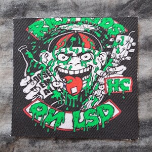 May include: Black square patch with a cartoon monkey wearing a red hat and dripping green slime. The monkey is holding a bottle and a guitar. Text includes "DOSE EM ALL", "HC", and "OK LSD".