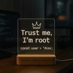 May include: An illuminated acrylic sign with the words "Trust me, I'm root" and a crown illustration. The sign is mounted on a wooden base with the text "Upgrade with engraving here". A cable is connected to the base.