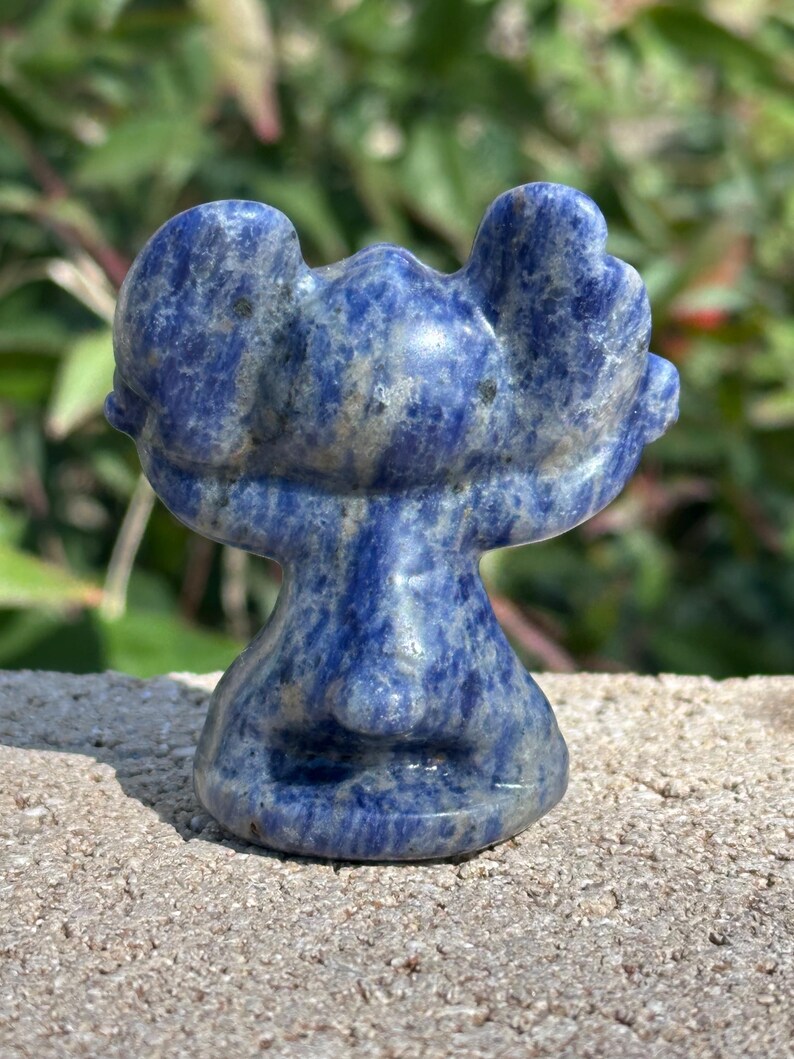 May include: A blue and white carved lapis lazuli sculpture of a moose. The moose is standing on its hind legs with its front legs raised in the air.