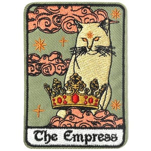 Op de afbeelding: Een geborduurde patch met een witte kat die een gouden kroon draagt, zittend op roze wolken. De tekst "The Empress" staat in wit onderaan de patch.