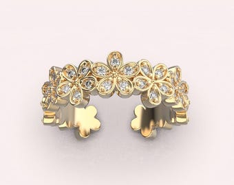 May include: A gold ring with a floral design. The ring is made up of five small flowers, each with a center stone and petals set with smaller stones.