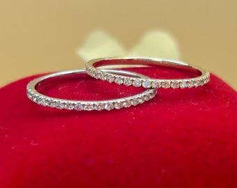 May include: Two thin silver bands with small diamonds set in a continuous line around the band.