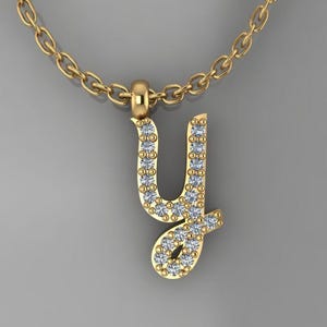 May include: A gold chain necklace with a pendant in the shape of the letter "Y". The pendant is encrusted with small, clear gemstones.