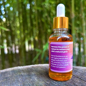 Może przedstawiać: Szklana butelka serumu z złotą zakrętką i kroplomierzem. Butelka jest oznaczona etykietą "Eternal Radiance" i zawiera napis "Harness the power of nature to restore your skin's natural glow".