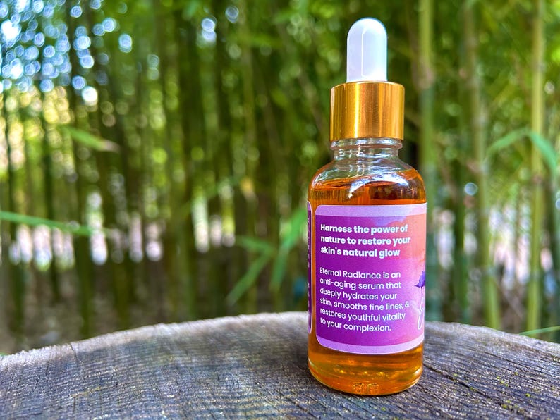 Może przedstawiać: Szklana butelka serumu z złotą zakrętką i kroplomierzem. Butelka jest oznaczona etykietą "Eternal Radiance" i zawiera napis "Harness the power of nature to restore your skin's natural glow".