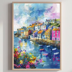 May include: Watercolor painting of a coastal village with colorful buildings and boats in the water. The artwork features a variety of colors, including blues, oranges, pinks, and greens. The painting is framed in a light wood frame.