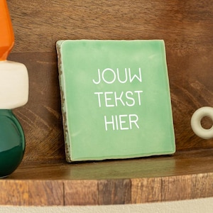 Può includere: Una piastrella di ceramica verde con testo bianco che dice "JOUW TEKST HIER".