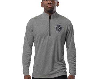 May include: A heather gray long-sleeve shirt with a zippered neck and a black embroidered logo on the left chest. The logo is a circle with the text "Settled Science University" inside.