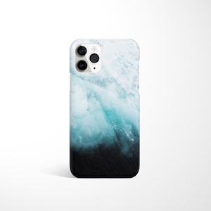 May include: A phone case with a blue and white abstract design that resembles ocean waves. The case has a black bottom and a white top with a blue wave pattern.