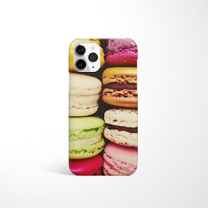 May include: A colourful phone case featuring a close-up image of a stack of macarons. The macarons are in various colours, including pink, green, yellow, and brown.