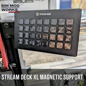Może przedstawiać: Czarny magnetyczny uchwyt Stream Deck XL z wieloma kwadratowymi przyciskami. Widoczne jest logo Stream Deck. Tekst "STREAM DECK XL MAGNETIC SUPPORT" jest wyświetlany na dole obrazu. Logo Sim Mod Works znajduje się w lewym górnym rogu.