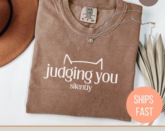 Camiseta "Juzgándote en Silencio", "Mujer Gatuna", "Mi Hijo Tiene Patas", "Mamá Gatuna", "Me Distraigo Fácilmente con los Gatos", "Miau", "Gato Introvertido"