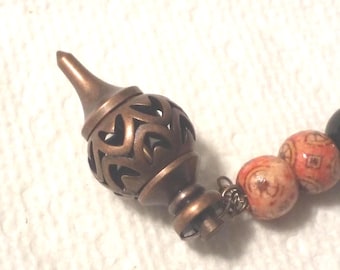 Unique pendulum, wood print beads. metal focal,  with black beads. 8 inches long. 116