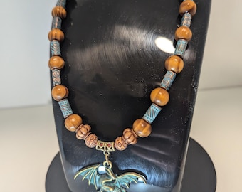 Beaded necklace with a dragon pendent, wood beads, and metal beads. 125