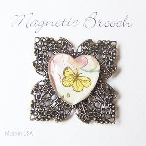 Magnetic brooch heart shaped glass dome with designer paper butterfly design antique brass tone magnet closure