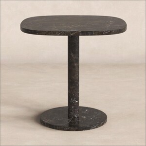 May include: A side table constructed from dark brown marble with white veining. The table features a rounded square tabletop supported by a single cylindrical central column that connects to a circular base, all finished in matching marble.