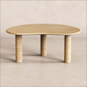 Könnte beinhalten: Ein niedriger Couchtisch aus beigem Travertin mit einer glatten, nierenförmigen Tischplatte, die von drei dicken, zylindrischen Beinen aus demselben Naturstein getragen wird und durchgehend sichtbare horizontale Maserungen aufweist.