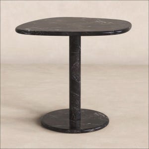 Pode incluir: Uma mesa lateral com um tampo de mármore preto liso com veios brancos. A mesa possui um pedestal central cilíndrico único que se conecta a uma base circular plana de mármore preto, criando uma aparência coesa e uniforme.
