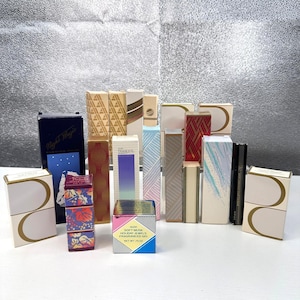 May include: A collection of various rectangular Avon perfume and fragrance product boxes in assorted colours and patterns, including Night Magic, Tranquil Moments, and Soft Musk Holiday Jewels Fragranced Gel with a net weight of 21 grams.