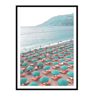 May include: A beach scene with a large number of green and white striped umbrellas and orange lounge chairs. The beach is sandy and there are people in the water and on the beach.