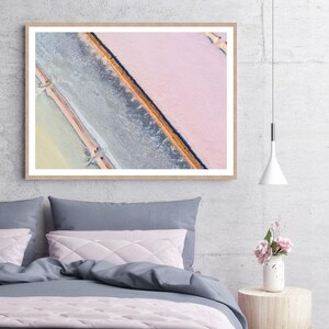 Op de afbeelding: Een luchtfoto van een zoutvlakte met een diagonale waterlijn die de roze en blauwe gebieden scheidt.