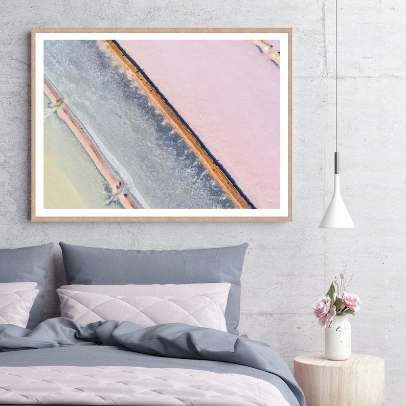 Op de afbeelding: Een luchtfoto van een zoutvlakte met een diagonale waterlijn die de roze en blauwe gebieden scheidt.