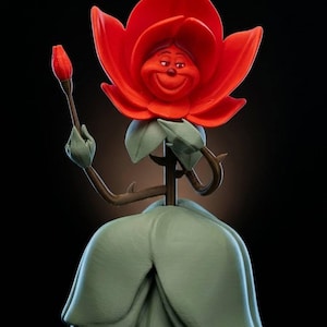 May include: A whimsical figurine of a smiling red rose with a green stem and leaves, holding a rosebud. The rose is wearing a green dress. The figurine is set against a black background.