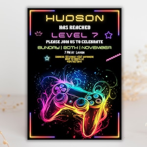 May include: A neon-colored video game controller graphic on a black background with the text "HUDSON HAS REACHED LEVEL 7 PLEASE JOIN US TO CELEBRATE SUNDAY | 20TH | NOVEMBER 7 PM AT LAVISH ADDRESS: 123 STREET 4567 ANYWHERE RSVP TO CRISTA AT 412476273641".