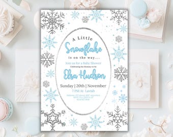Könnte beinhalten: Eine weiße Babyparty-Einladung mit einem blauen und silbernen Schneeflocken-Design. Der Text lautet "A Little Snowflake is on the way... Join us for a Baby Shower Celebrating the Mommy-to-be Elsa Hudson Sunday | 20th | November 7 PM At Lavish Addres 123 street 4567 anywhere RSVP TO CRISTA AT 412476273641"