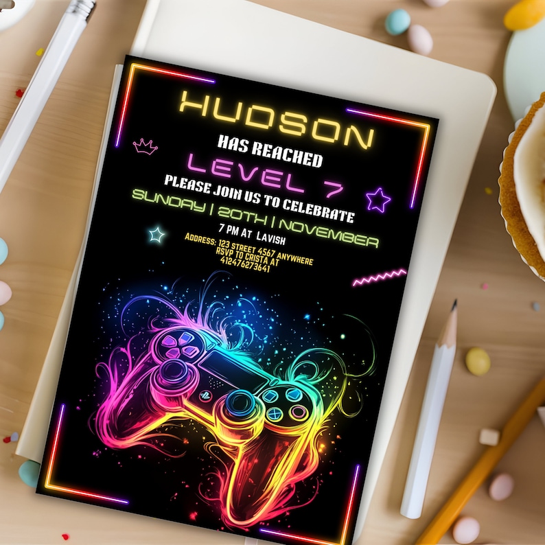 May include: Neon gamer birthday party invitation with a black background and a colorful video game controller graphic. The text reads "HUDSON HAS REACHED LEVEL 7 PLEASE JOIN US TO CELEBRATE SUNDAY | 20TH | NOVEMBER 7 PM AT LAVISH ADDRESS: 123 STREET 4567 ANYWHERE RSVP TO CRISTA AT 412476273641"