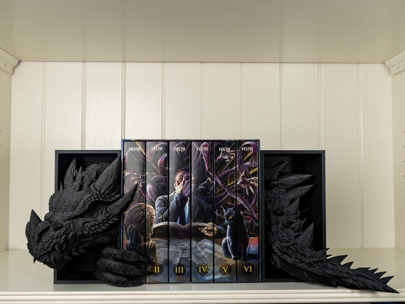 May include: A set of six black and white hardcover books with the title "FESTR" on the spine. The books are arranged in a row on a shelf with black dragon bookends on either side. The books are numbered III, IV, V, and VI.