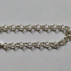 Puede incluir: Un brazalete de cadena de plata con cierre de langosta.
