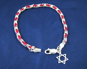 May include: A red and silver braided bracelet with a silver Star of David charm.