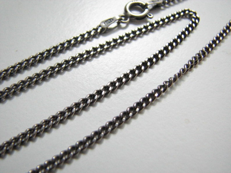 Puede incluir: Un collar de cadena de plata con cierre de langosta. La cadena es de estilo curb con un dise&ntilde;o trenzado.