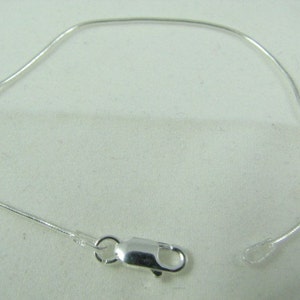 May include: A silver chain bracelet with a lobster clasp closure.