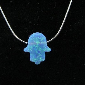 May include: A silver chain necklace with a blue opal hamsa hand pendant.