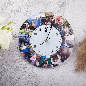 Könnte beinhalten: Runde Wanduhr mit weißem Zifferblatt, schwarzen Zahlen und Zeigern. Der äußere Ring der Uhr ist mit mehreren Familienfotos verziert. Die Uhr ist an einer strukturierten, hellgrauen Wand befestigt.