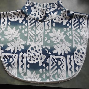 May include: A white and blue patterned turtleneck collar with a scalloped edge.