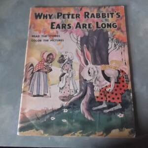 May include: A vintage children's book titled "Why Peter Rabbit's Ears Are Long." The cover features a white rabbit with long ears wearing a red and white polka dot dress and a black vest. The rabbit is standing next to a tree with green leaves and a brown trunk. The book also features two black and white characters with white accents. The book cover has a light blue background with white flowers.