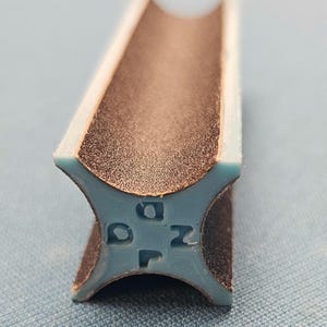 May include: A brown sanding block with a blue plastic end cap. The end cap has the letters "D", "O", "Z", and "P" printed on it.