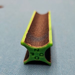 Può includere: Uno strumento per modellare la punta del biliardo verde e nero con la scritta "200" stampata sul lato.
