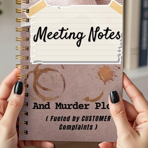 May include: A pinkish-brown notebook with gold spiral binding. The cover reads "Meeting Notes" and "And Murder Plans (Fueled by CUSTOMER Complaints)". The design includes a torn paper effect and coffee stain marks.