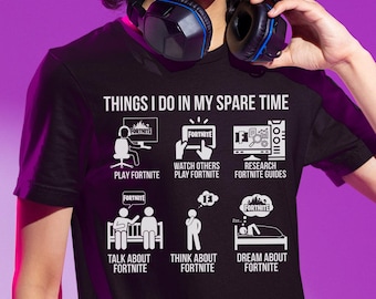 May include: Black t-shirt with the text "THINGS I DO IN MY SPARE TIME" and illustrations of activities related to the video game Fortnite. The activities include playing, watching, researching, talking, thinking, and dreaming about Fortnite.